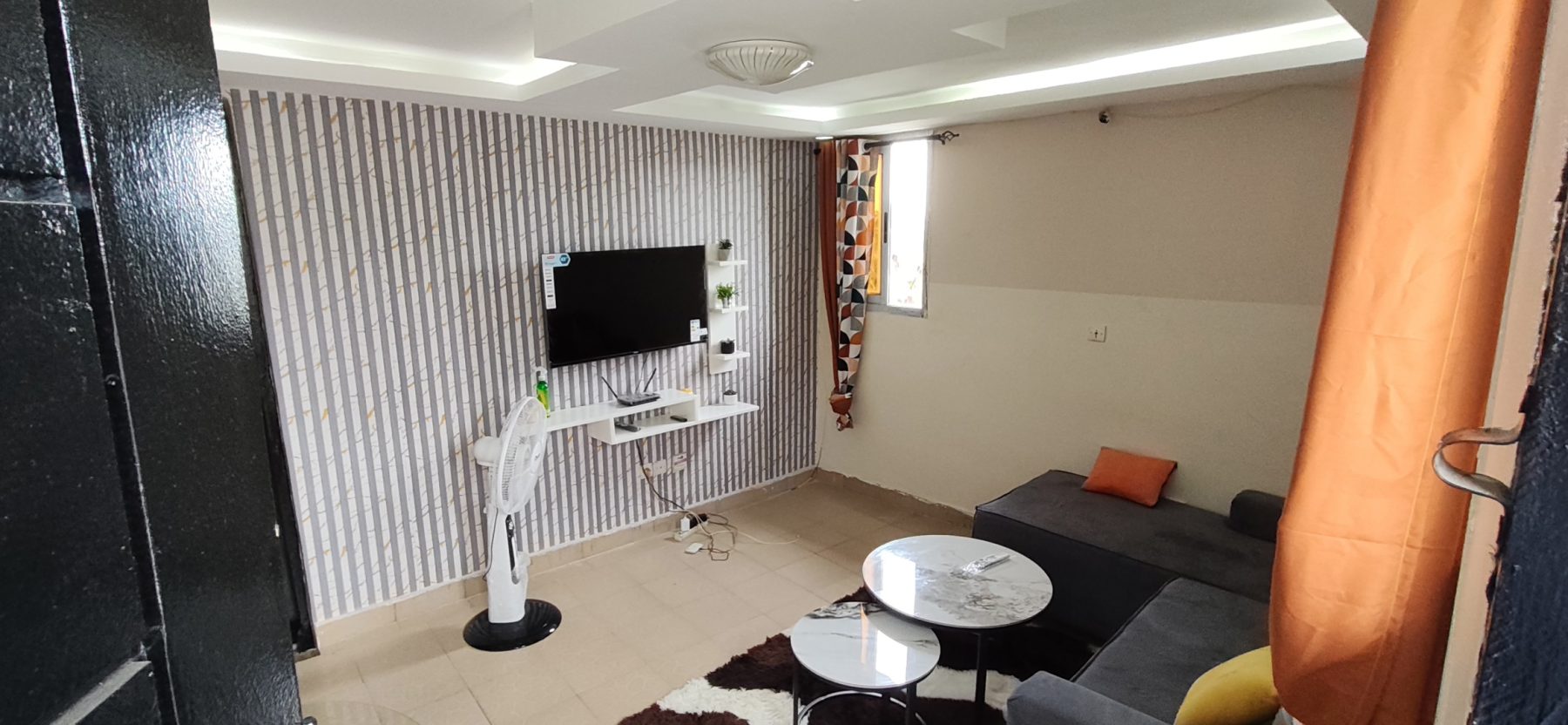 Salon avec canapé et ventilateur
